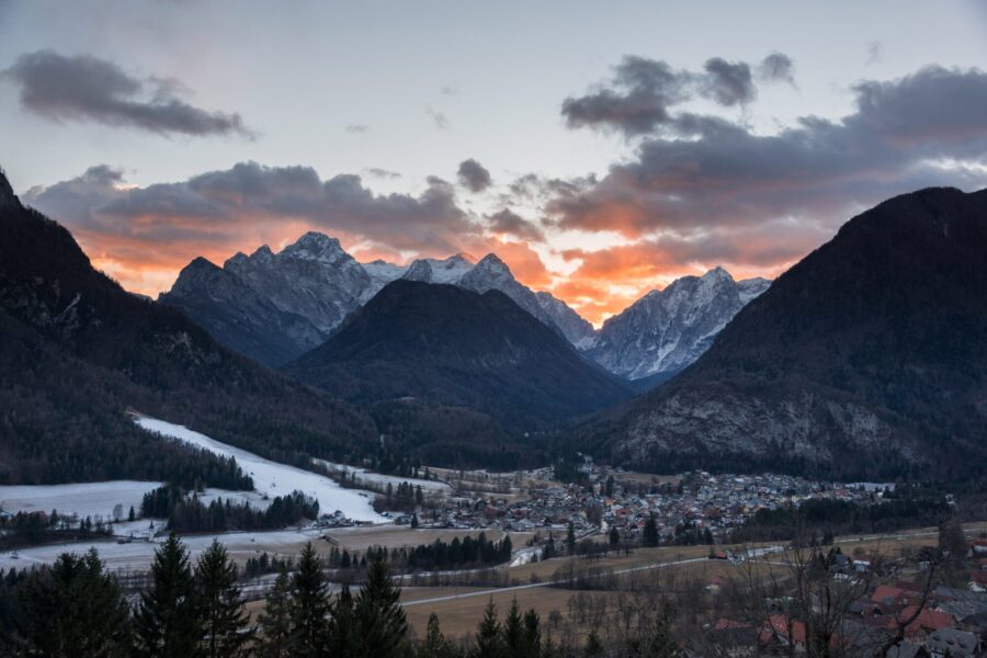 Bilde av fjell som ligger bak en by i solnedgang